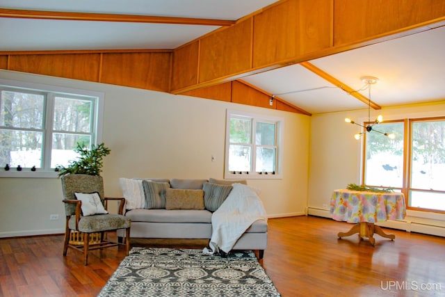 living room featuring lofted ceiling with beams, wood-type flooring, and an inviting chandelier