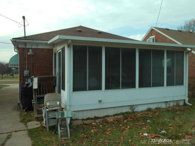 view of side of home featuring a sunroom