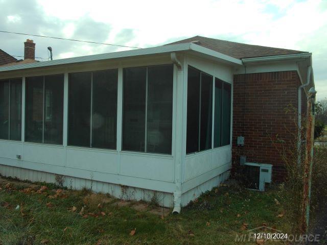 view of property exterior with a sunroom