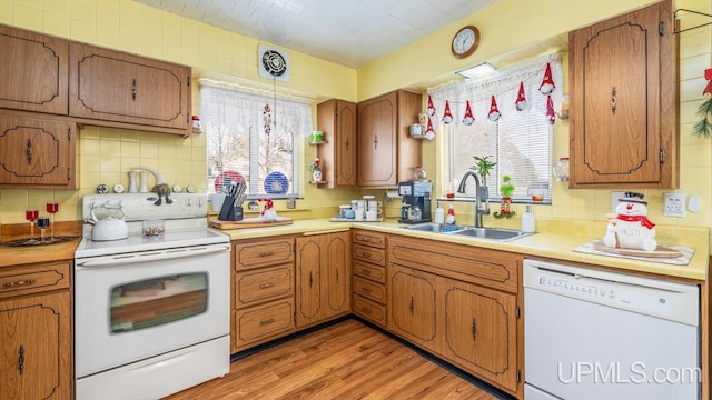 kitchen with decorative light fixtures, sink, a healthy amount of sunlight, and white appliances