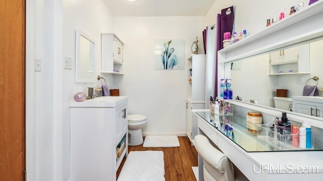 bathroom featuring hardwood / wood-style floors, vanity, and toilet