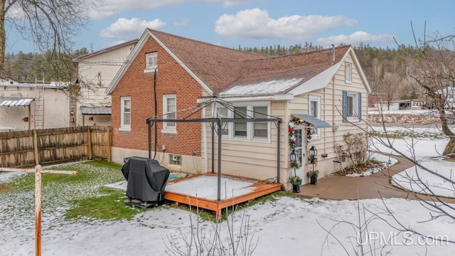 view of snow covered back of property