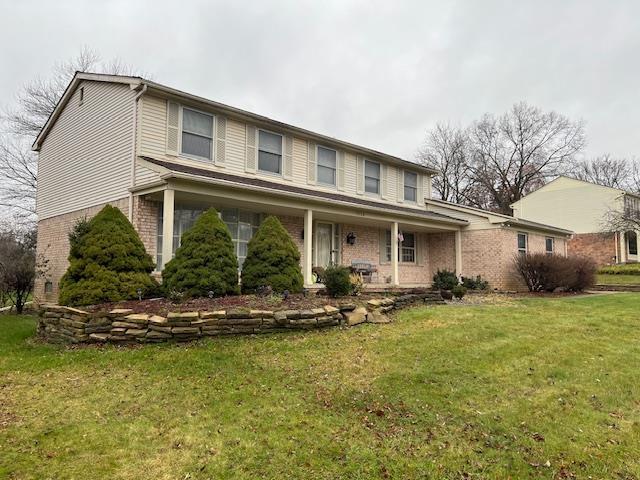 view of front property featuring covered porch and a front lawn