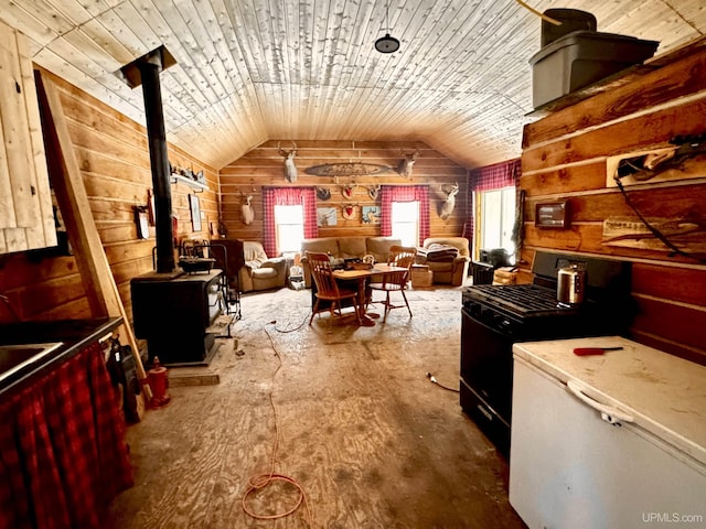 interior space with a wood stove, wooden walls, and lofted ceiling