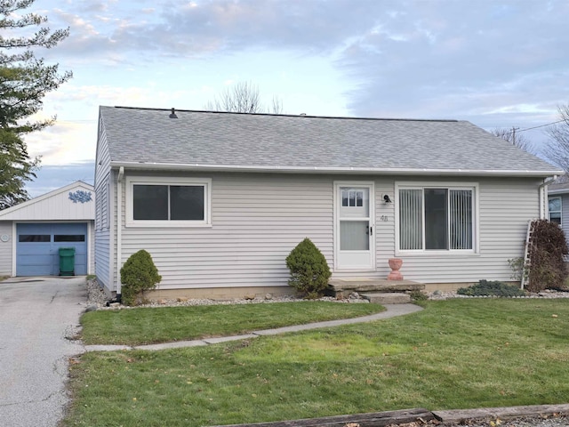 ranch-style home with an outbuilding, a front lawn, and a garage