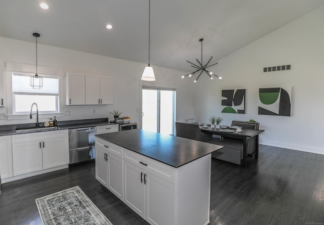 kitchen featuring dishwasher, sink, pendant lighting, lofted ceiling, and white cabinets