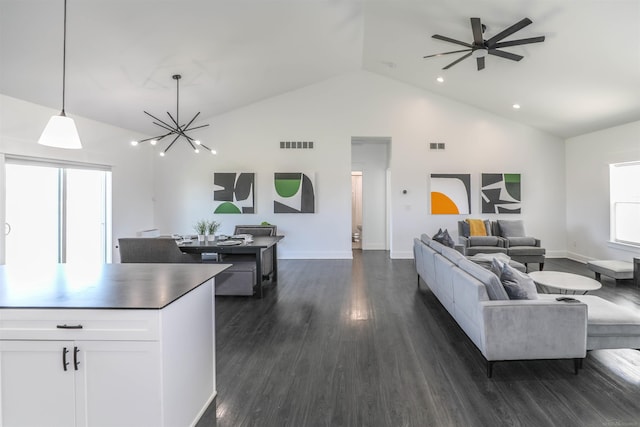 living room with dark hardwood / wood-style flooring, high vaulted ceiling, and ceiling fan with notable chandelier