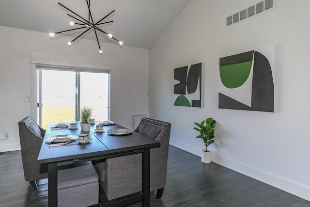 dining space with lofted ceiling, dark hardwood / wood-style floors, and an inviting chandelier