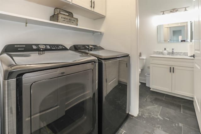 laundry area with cabinets, separate washer and dryer, and sink