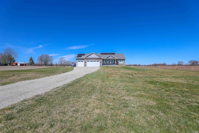 view of front facade featuring solar panels, a garage, a rural view, and a front yard