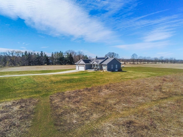 view of yard featuring a rural view and a garage