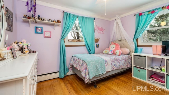 bedroom with hardwood / wood-style flooring, ceiling fan, and a baseboard radiator