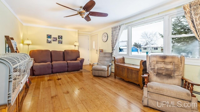 living room with crown molding, plenty of natural light, and light hardwood / wood-style flooring