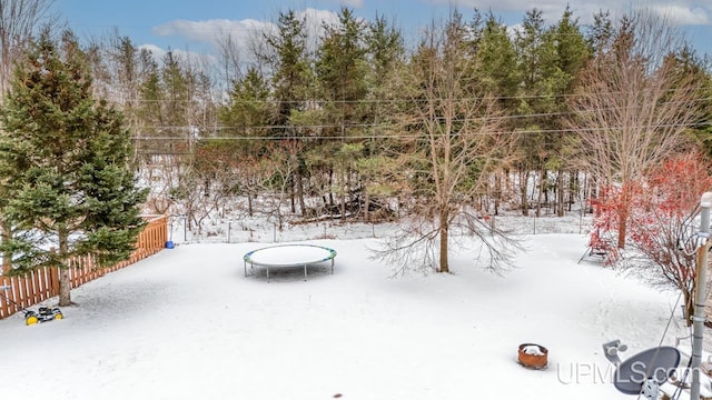 yard covered in snow with a trampoline