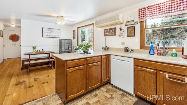 kitchen featuring kitchen peninsula, ceiling fan, sink, an AC wall unit, and dishwasher