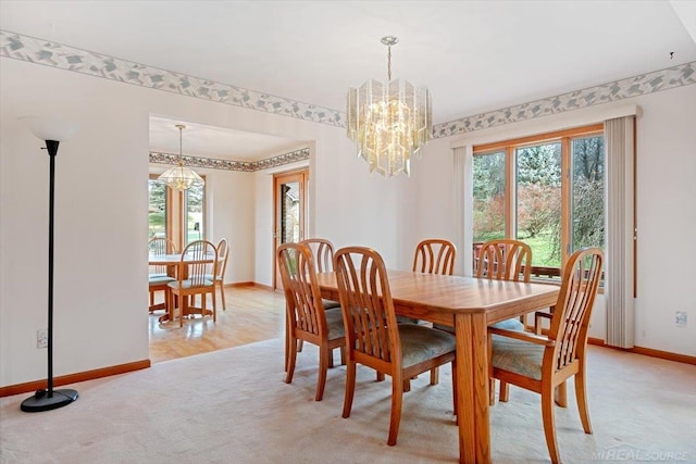 dining room with light hardwood / wood-style floors and an inviting chandelier