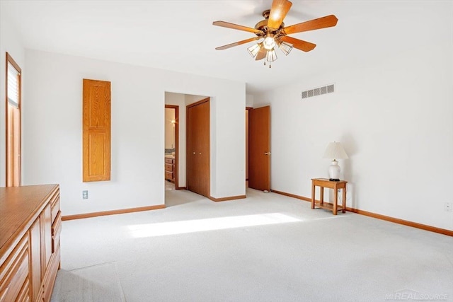 unfurnished bedroom featuring light carpet, connected bathroom, and ceiling fan