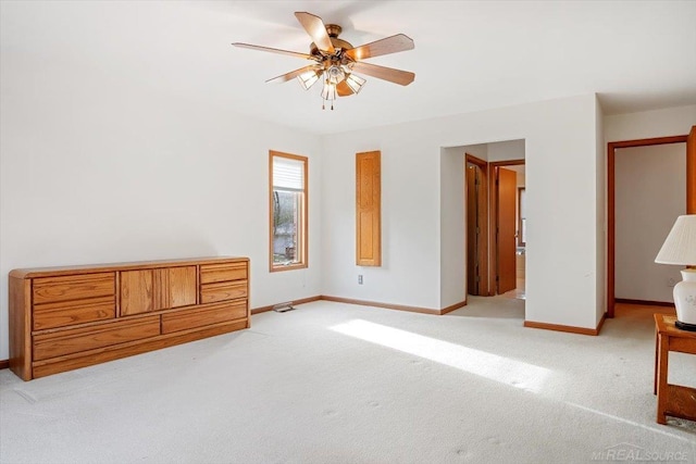 unfurnished bedroom with light colored carpet, ceiling fan, and ensuite bathroom