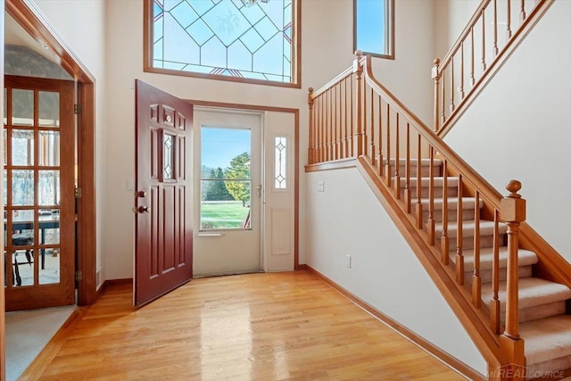 foyer entrance featuring light hardwood / wood-style floors and a high ceiling