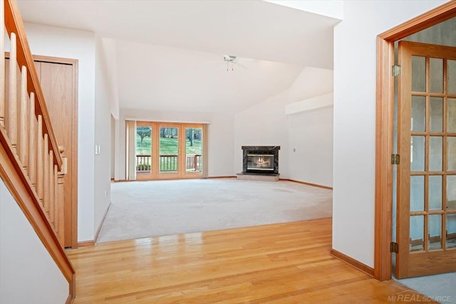 unfurnished living room with light colored carpet and vaulted ceiling