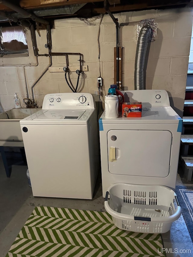 laundry area with separate washer and dryer and sink