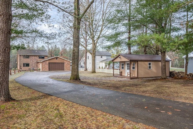 view of front of house featuring a garage and an outbuilding