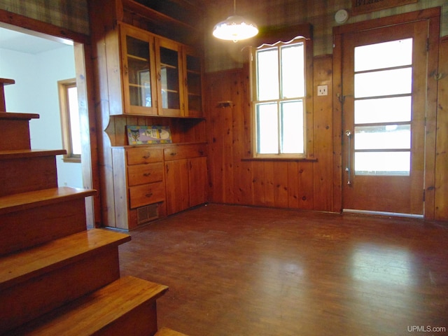 kitchen featuring decorative light fixtures, wood walls, and dark hardwood / wood-style flooring