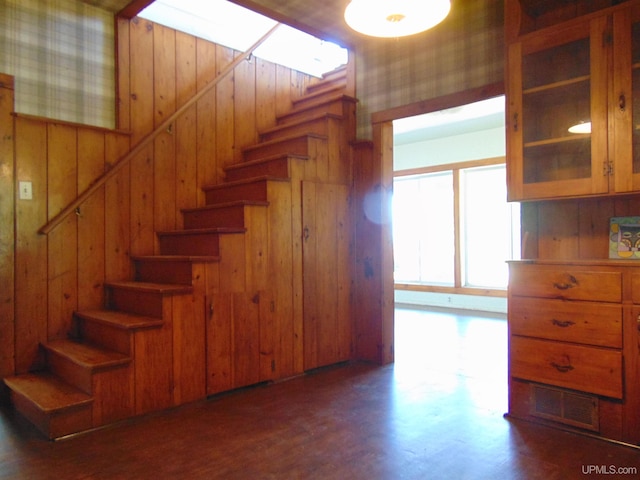 stairway featuring wood walls and wood-type flooring