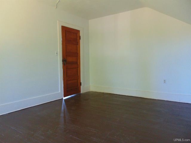 spare room with dark hardwood / wood-style floors and lofted ceiling