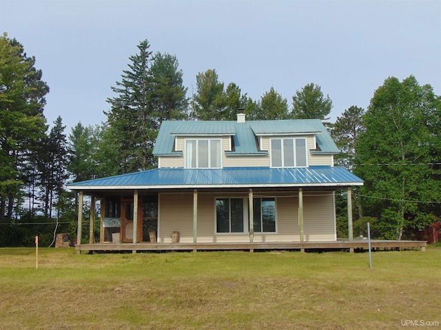 rear view of house featuring a porch and a lawn