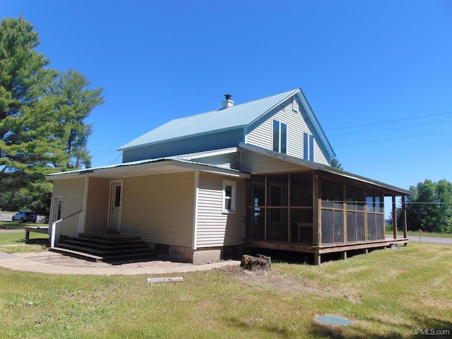 view of side of property featuring a yard and a sunroom