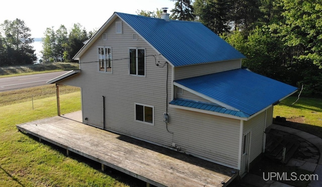 rear view of house featuring a deck and a yard