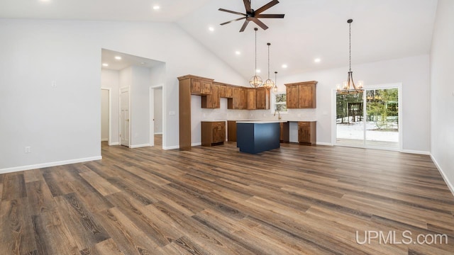 unfurnished living room with ceiling fan with notable chandelier, dark hardwood / wood-style floors, and high vaulted ceiling