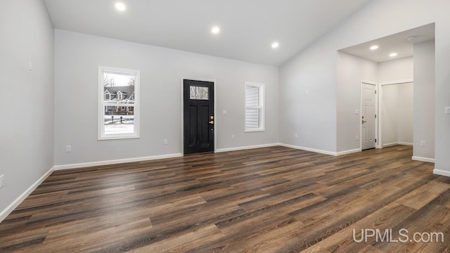 foyer entrance featuring dark wood-type flooring and high vaulted ceiling