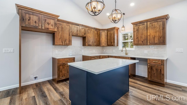 kitchen with a center island, decorative light fixtures, an inviting chandelier, sink, and vaulted ceiling