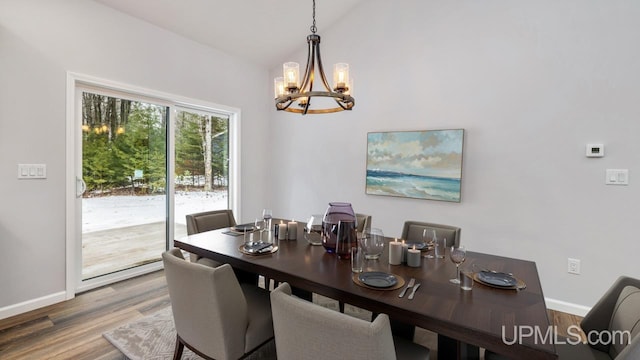 dining area with hardwood / wood-style floors and a notable chandelier