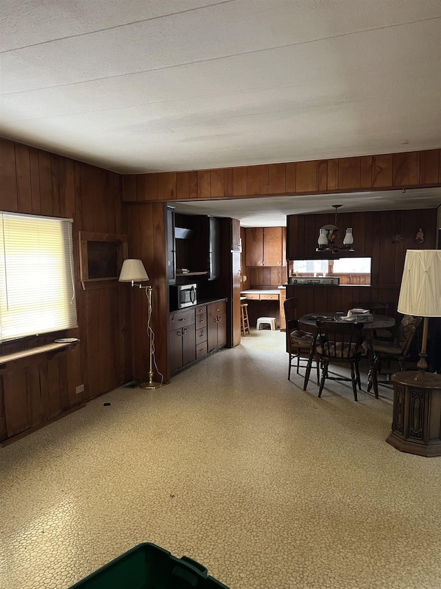 kitchen featuring dark brown cabinets and wood walls