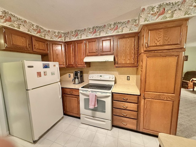 kitchen with a textured ceiling, light tile patterned flooring, and white appliances