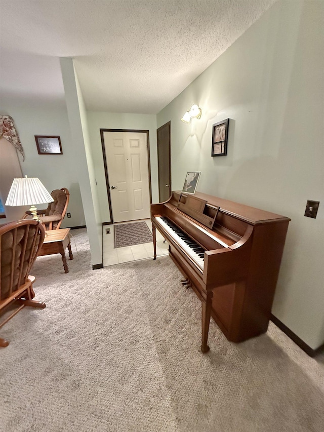 miscellaneous room featuring a textured ceiling and light colored carpet