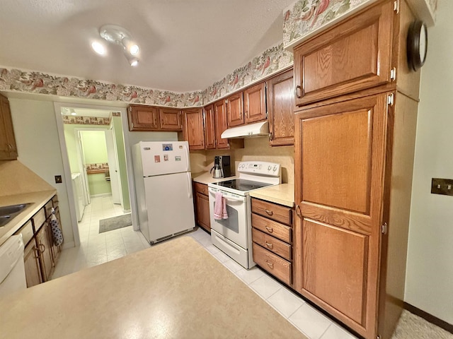 kitchen with light tile patterned floors, white appliances, and sink