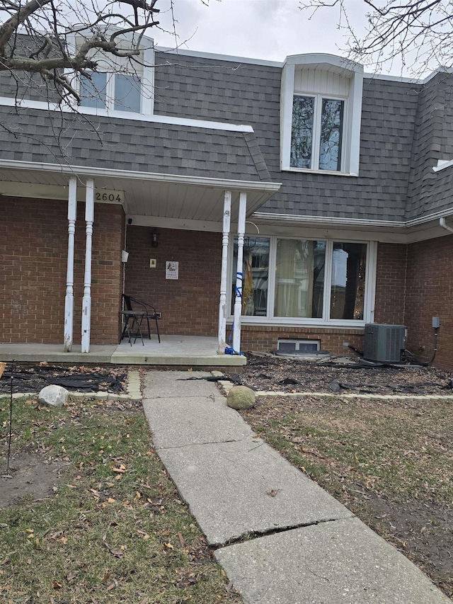 doorway to property featuring covered porch and central AC unit