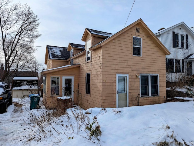 view of snow covered rear of property