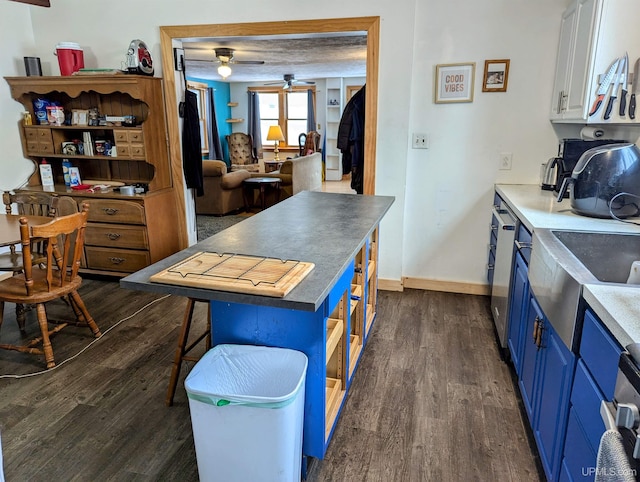 kitchen featuring a breakfast bar, ceiling fan, blue cabinetry, dark hardwood / wood-style flooring, and white cabinetry