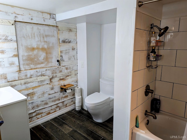 full bathroom featuring hardwood / wood-style floors, vanity, toilet, and tiled shower / bath