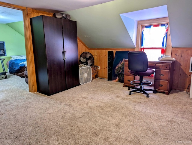 carpeted office with lofted ceiling and wood walls