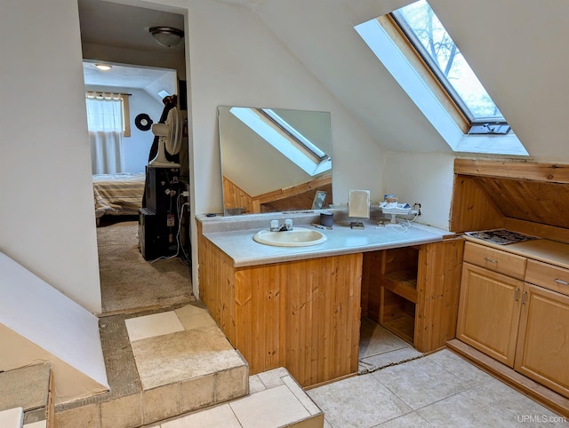 bathroom featuring tile patterned floors, vanity, and vaulted ceiling