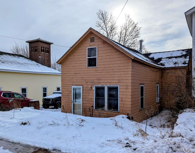 view of snow covered back of property