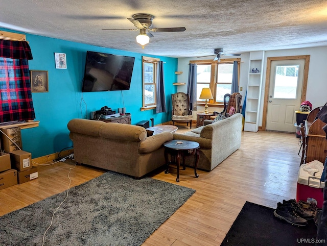 living room with a wealth of natural light, a textured ceiling, and hardwood / wood-style flooring