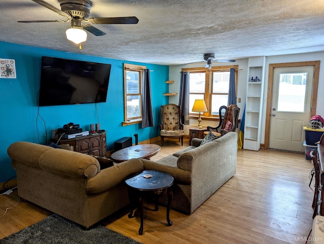 living room featuring a wealth of natural light, light hardwood / wood-style flooring, ceiling fan, and a textured ceiling