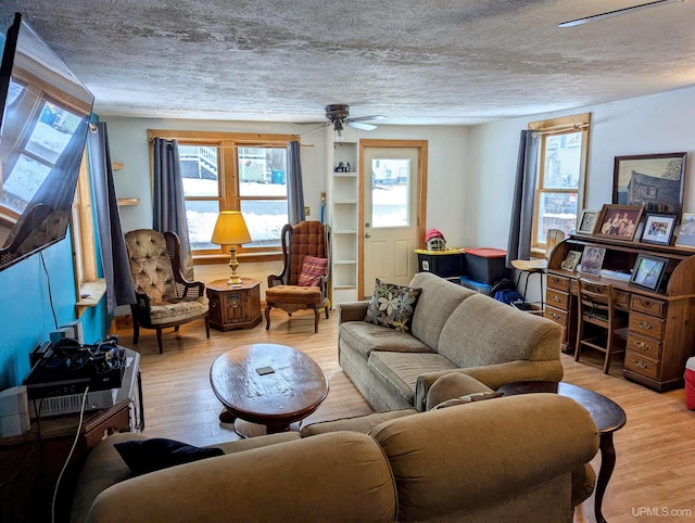 living room with plenty of natural light, light hardwood / wood-style floors, and a textured ceiling